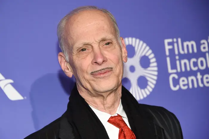John Waters smiles for the camera, with his distinctive mustache